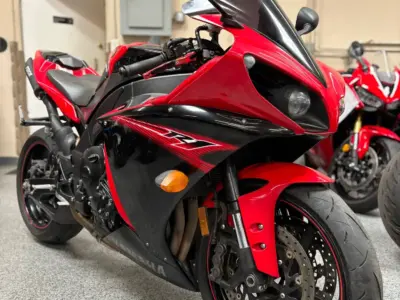 Side view of a pre-owned sport/standard motorcycle parked indoors at a motorcycle dealership.