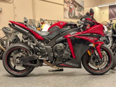 Red Yamaha sport bike with black accents, shown from side view in a motorcycle showroom.