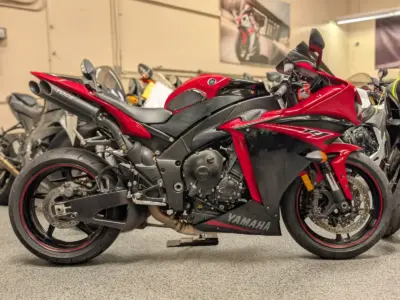 Red Yamaha sport bike with black accents, shown from side view in a motorcycle showroom.